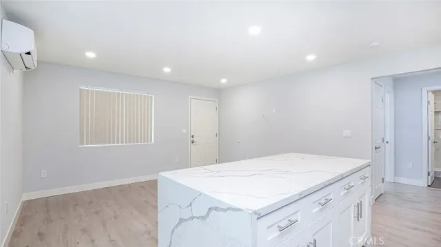 a room with a kitchen island a sink dishwasher and a refrigerator