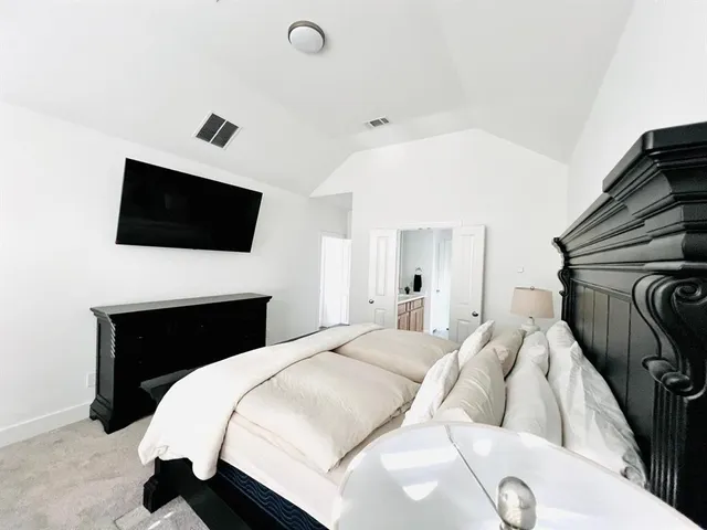 a bedroom with a bed and a flat screen tv