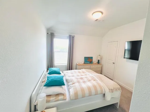 a bedroom with a bed and a flat screen tv