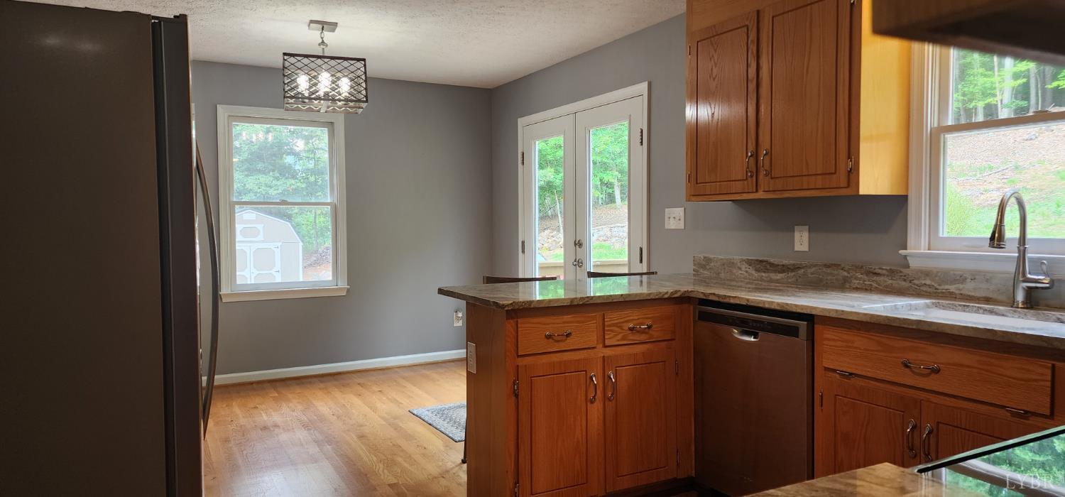 297 Poor House Farm Road Amherst, VA 24521 - Photo 14 of 52 a kitchen with granite countertop wooden cabinets a sink a window and stainless steel appliances