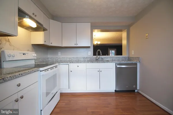 a kitchen with granite countertop cabinets stainless steel appliances and a sink