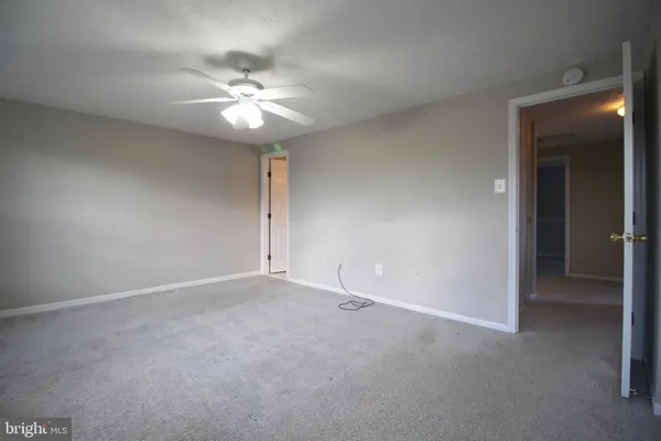 a view of an empty room and a fan