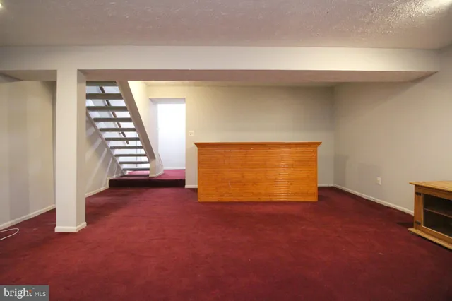 an empty room with windows and fireplace