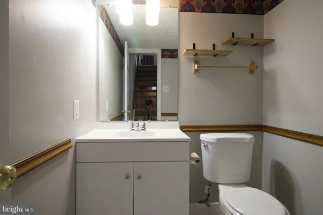 a bathroom with a sink and mirror with toilet