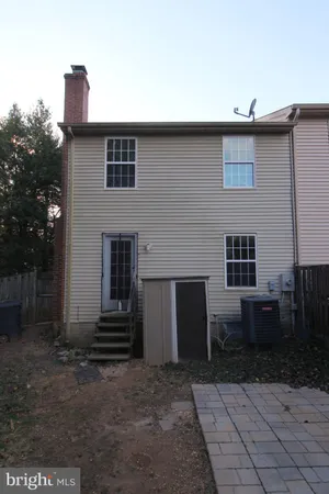 a backyard of a house with barbeque oven and brick wall