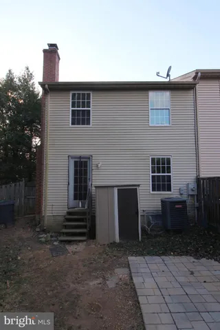 a backyard of a house with barbeque oven and brick wall