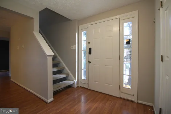 a view of a hallway with wooden floor and entryway