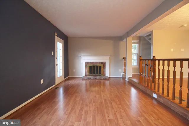 a view of empty room with wooden floor and fireplace