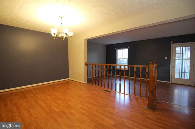 a view of a livingroom with wooden floor and stairs