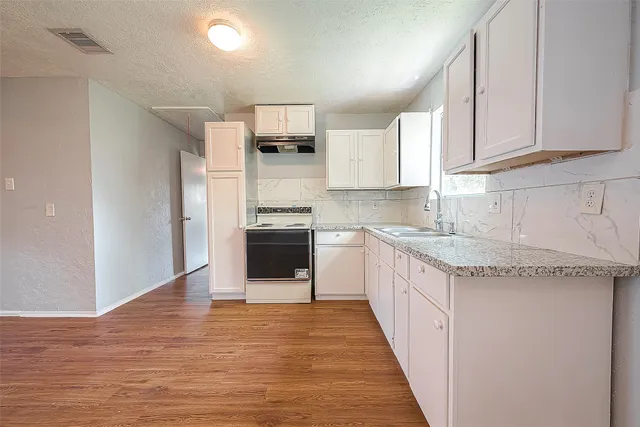 a kitchen with stainless steel appliances granite countertop a sink and a stove