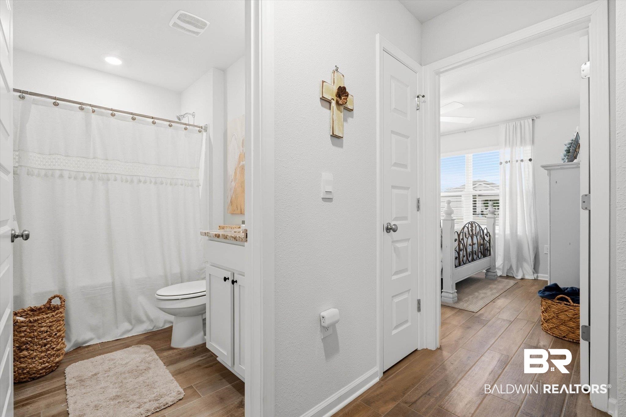 17041 Muse Street Loxley, AL 36551 - Photo 20 of 44 Full bathroom with dark wood finished floors, vanity, and shower / bathtub combination with curtain