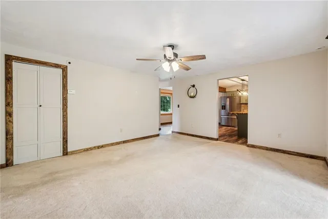 an empty room with closet and a ceiling fan
