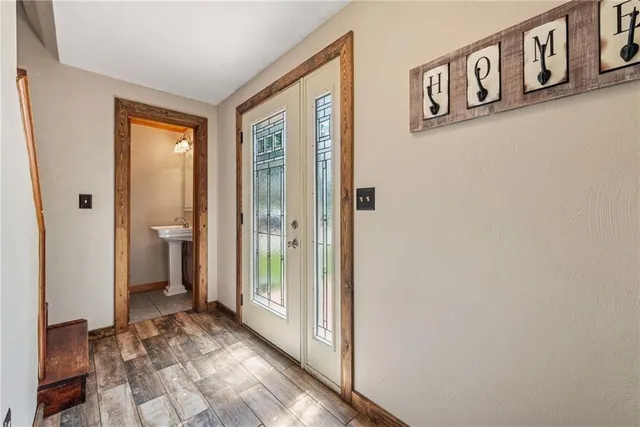 a view of a hallway with bathroom and wooden floor