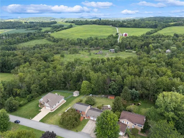 an aerial view of a houses with a lush green hillside