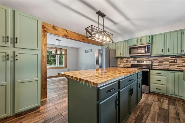 a kitchen with stainless steel appliances granite countertop a stove refrigerator and microwave