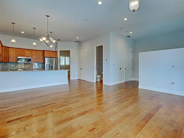 a view of a hallway with wooden floor and a living room