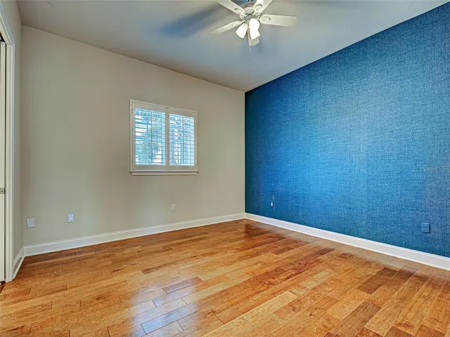 a view of empty room with wooden floor and bathroom