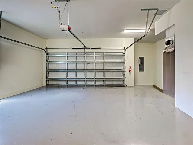 a view of a patio with a table and chairs floor to ceiling window and wooden fence