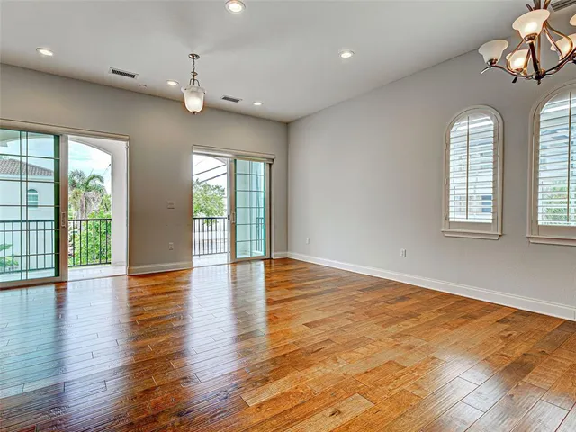 a living room with furniture kitchen view and a chandelier