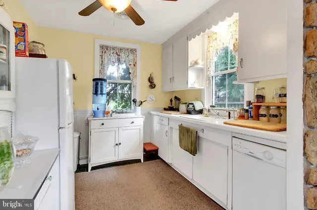 a kitchen with white cabinets and white appliances