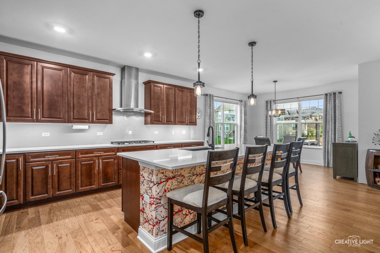 3638 Emerald Road Elgin, IL 60124 - Photo 6 of 18 a kitchen with stainless steel appliances granite countertop wooden floor cabinets dining table and chairs