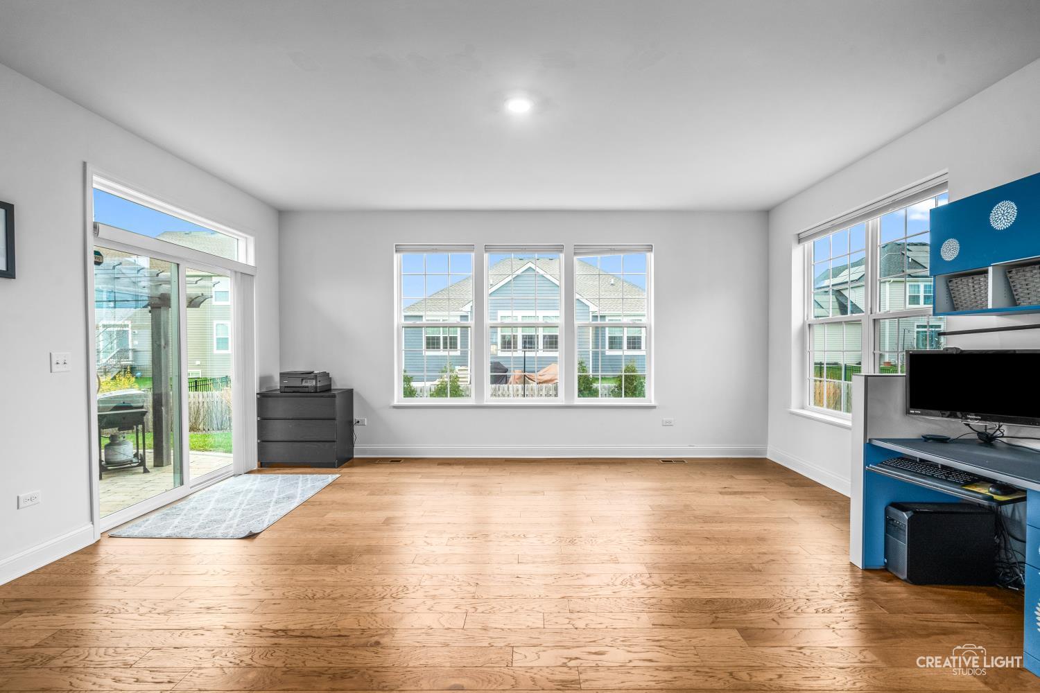 3638 Emerald Road Elgin, IL 60124 - Photo 8 of 18 a view of an empty room with a window and wooden floor