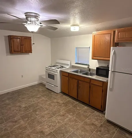 a kitchen with a stove a sink and a refrigerator