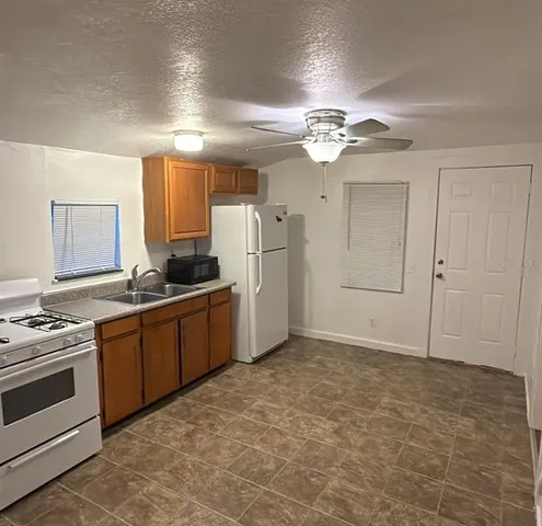 a kitchen with a refrigerator a stove top oven and cabinets