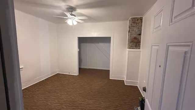 wooden floor in an empty room with a ceiling fan