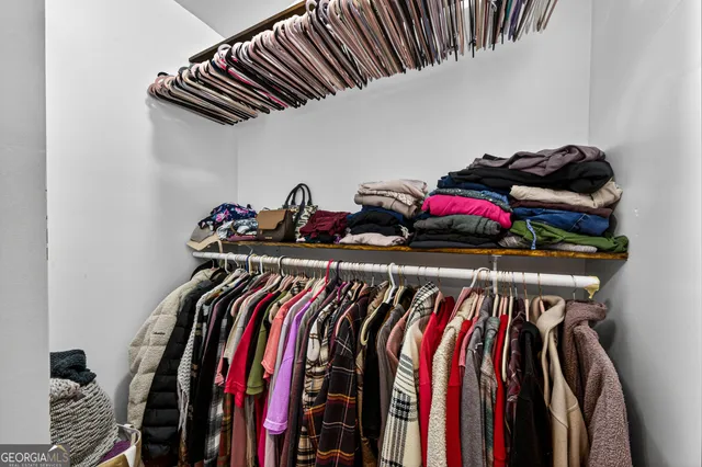 a view of walk in closet with clothes and shoes