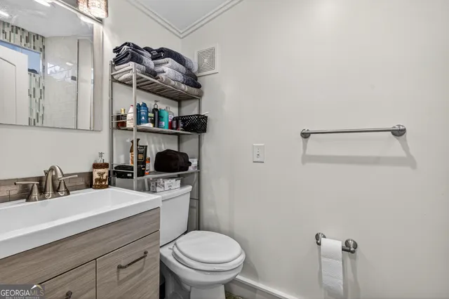 a bathroom with a toilet sink and mirror