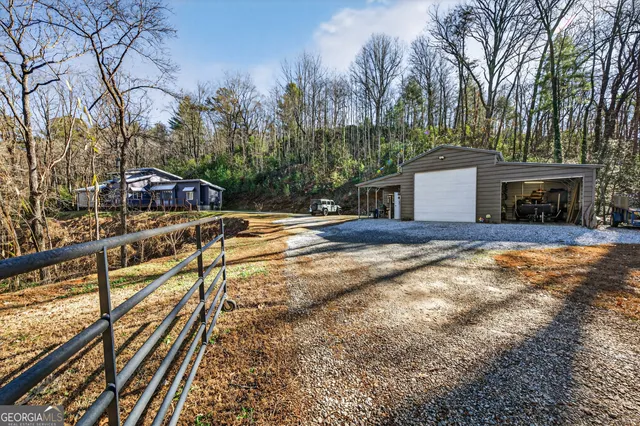 a view of a house with backyard and trees