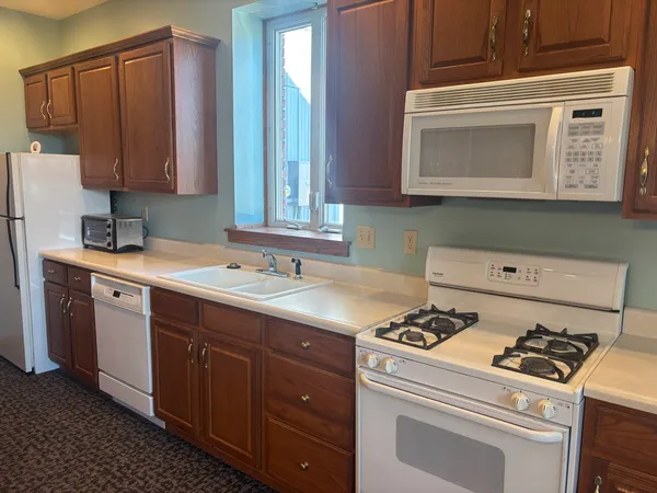 a view of kitchen with cabinets and refrigerator