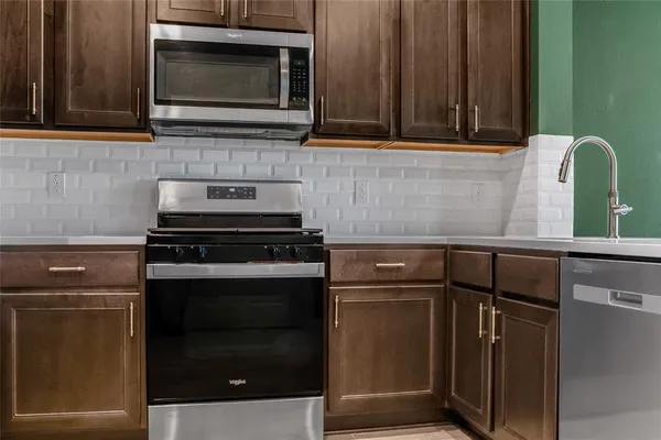a kitchen with granite countertop cabinets stainless steel appliances and wooden cabinets