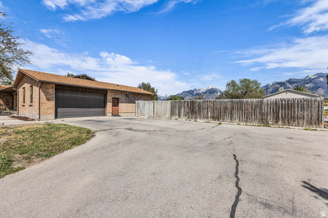 10705 Green Ridge Drive Sandy, UT 84070 - Photo 6 of 55 View of front of house with brick siding, a mountain view, a garage, asphalt driveway, and roof with shingles