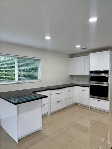 a kitchen with granite countertop white cabinets and white appliances