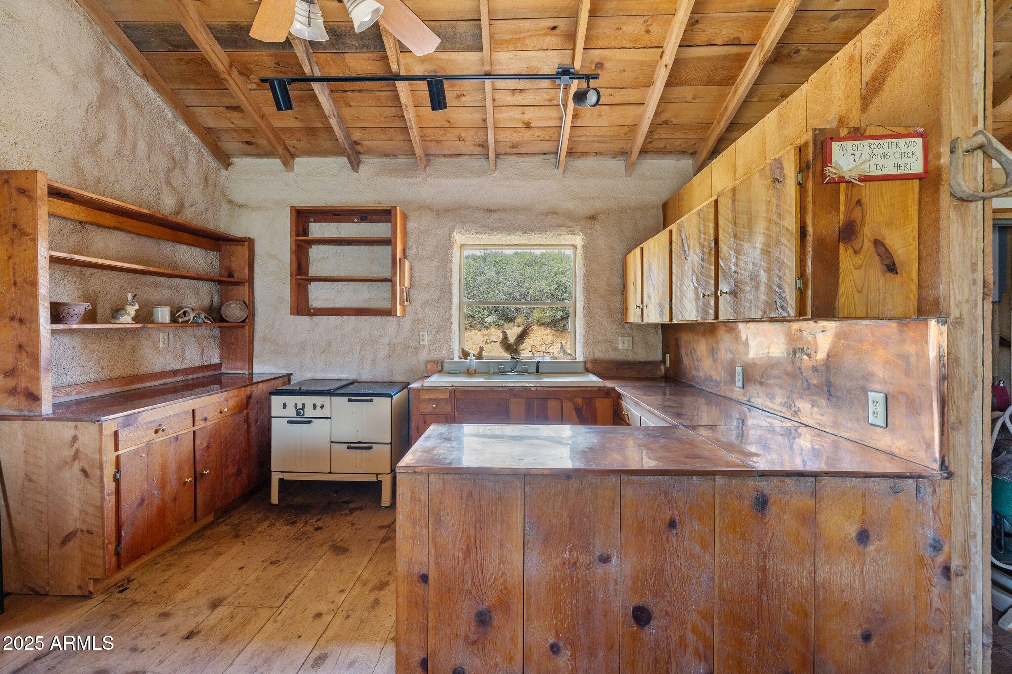9955 East Iron King Road Mayer, AZ 86333 - Photo 14 of 41 a kitchen with stainless steel appliances granite countertop a sink a stove cabinets counter space and a window