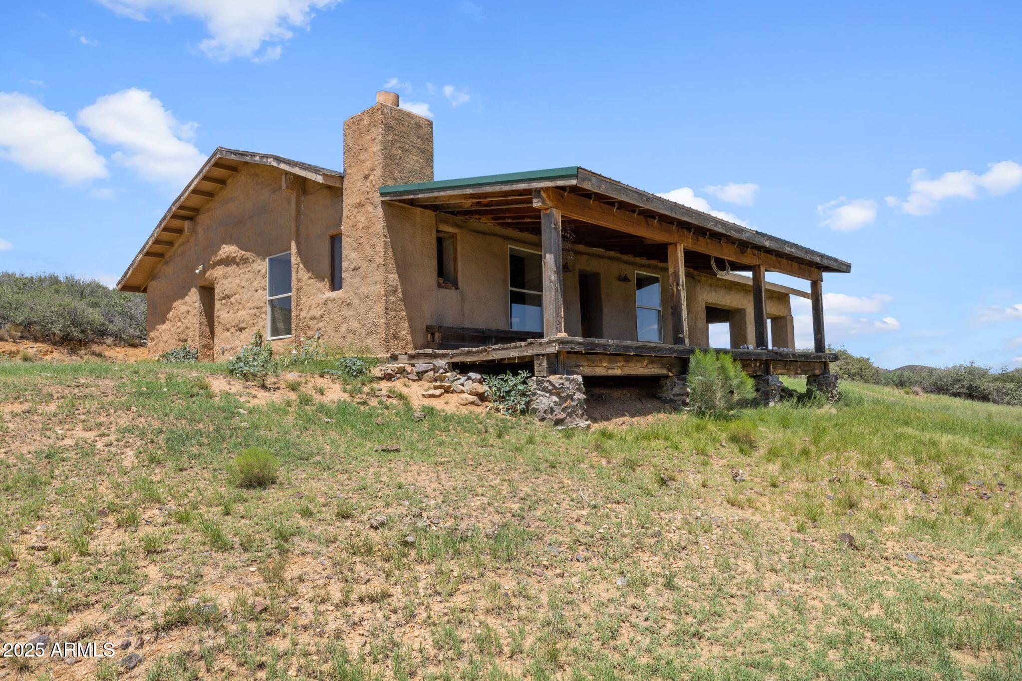 9955 East Iron King Road Mayer, AZ 86333 - Photo 2 of 41 a front view of a house with garden