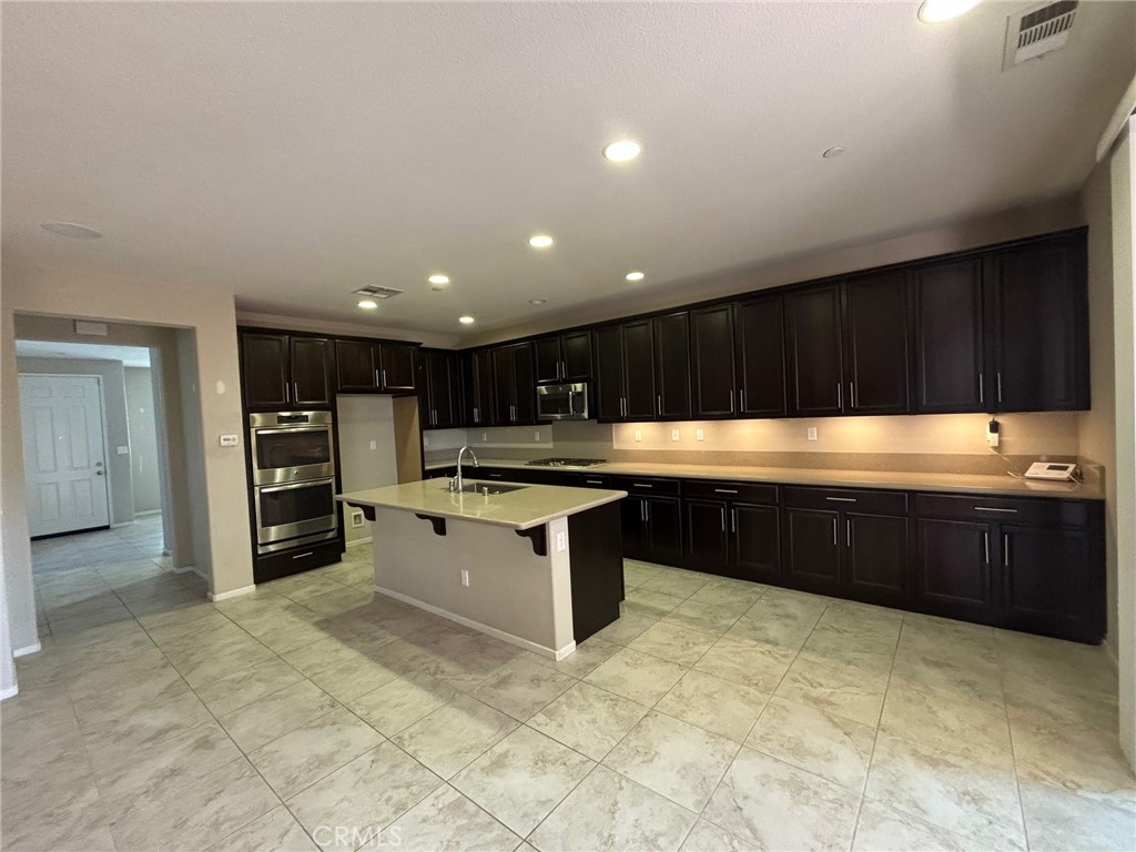 3288 Ledgewood Circle Riverside, CA 92503 - Photo 2 of 6 a kitchen with stainless steel appliances granite countertop a large counter top and a stove top oven