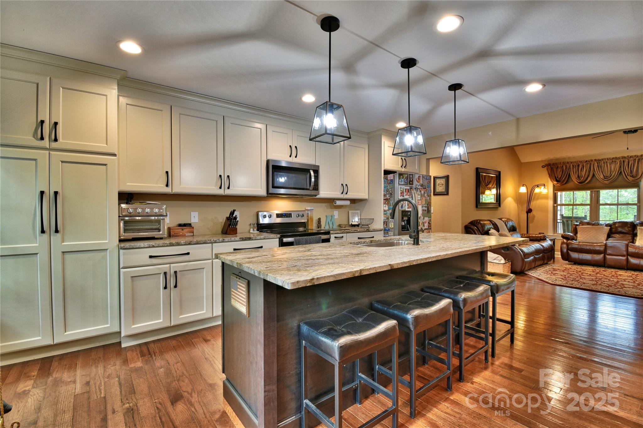 482 Old Camp Road Denton, NC 27239 - Photo 16 of 48 a kitchen with stainless steel appliances kitchen island granite countertop a stove a sink a oven a dining table and chairs with wooden floor