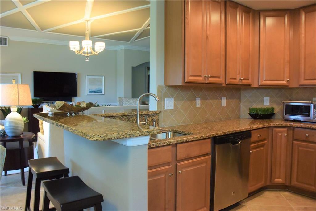 3161 Aviamar Circle, Unit 101 Naples, FL 34114 - Photo 15 of 32 a kitchen with granite countertop a sink stainless steel appliances and cabinets