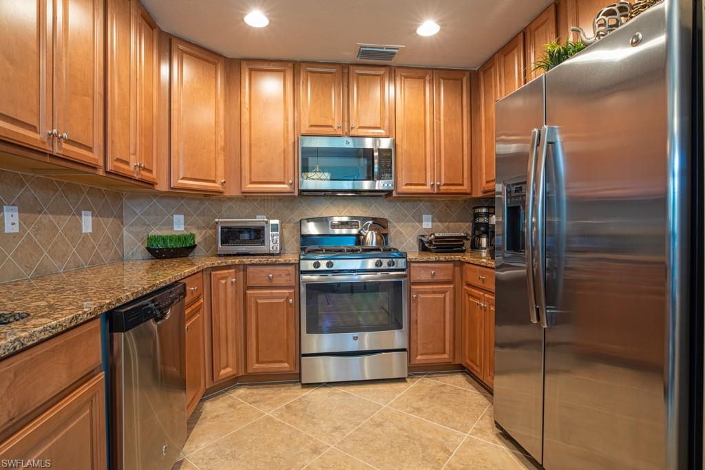 3161 Aviamar Circle, Unit 101 Naples, FL 34114 - Photo 16 of 32 a kitchen with stainless steel appliances granite countertop a stove a refrigerator and a sink