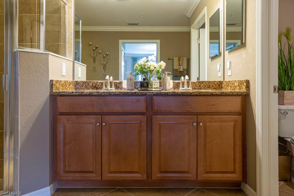 3161 Aviamar Circle, Unit 101 Naples, FL 34114 - Photo 8 of 32 a bathroom with a granite countertop sink and a mirror