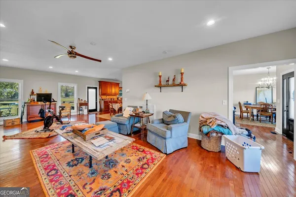 a living room with furniture kitchen view and a wooden floor