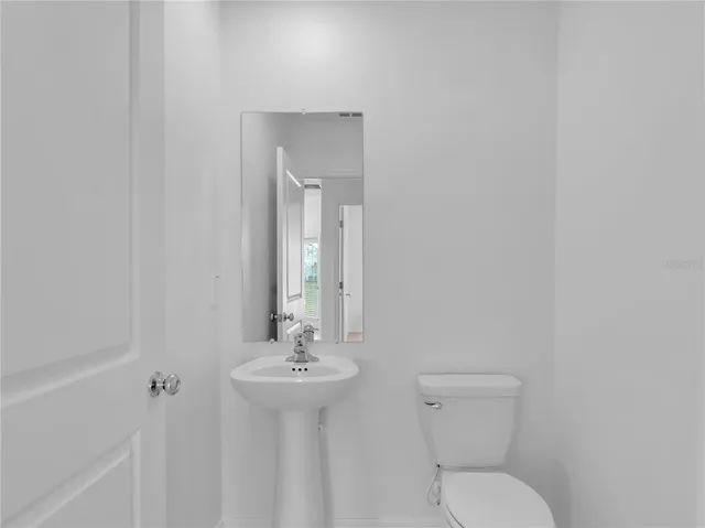 a bathroom with a toilet a sink and mirror