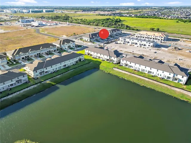 an aerial view of residential houses with outdoor space and ocean view