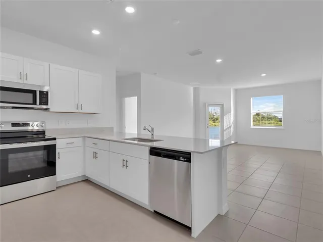 a kitchen with granite countertop white cabinets and appliances