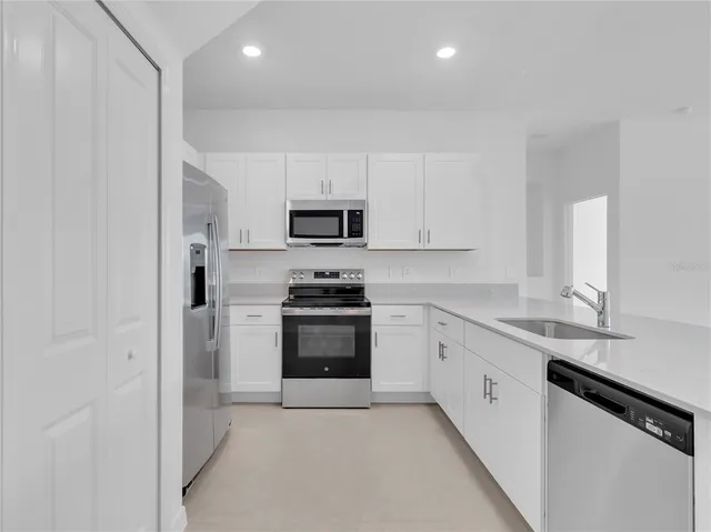 a kitchen with cabinets stainless steel appliances and a sink