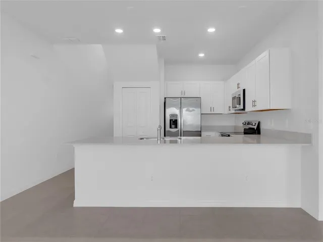 a large white kitchen with stainless steel appliances