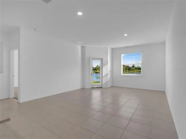 an empty room with windows and mirror